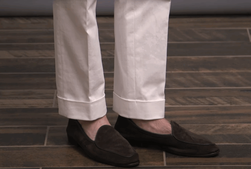 Bele keper pantalone, bež košulja, teget sako, braon mokasine i kaiš za poslovni casual stil.